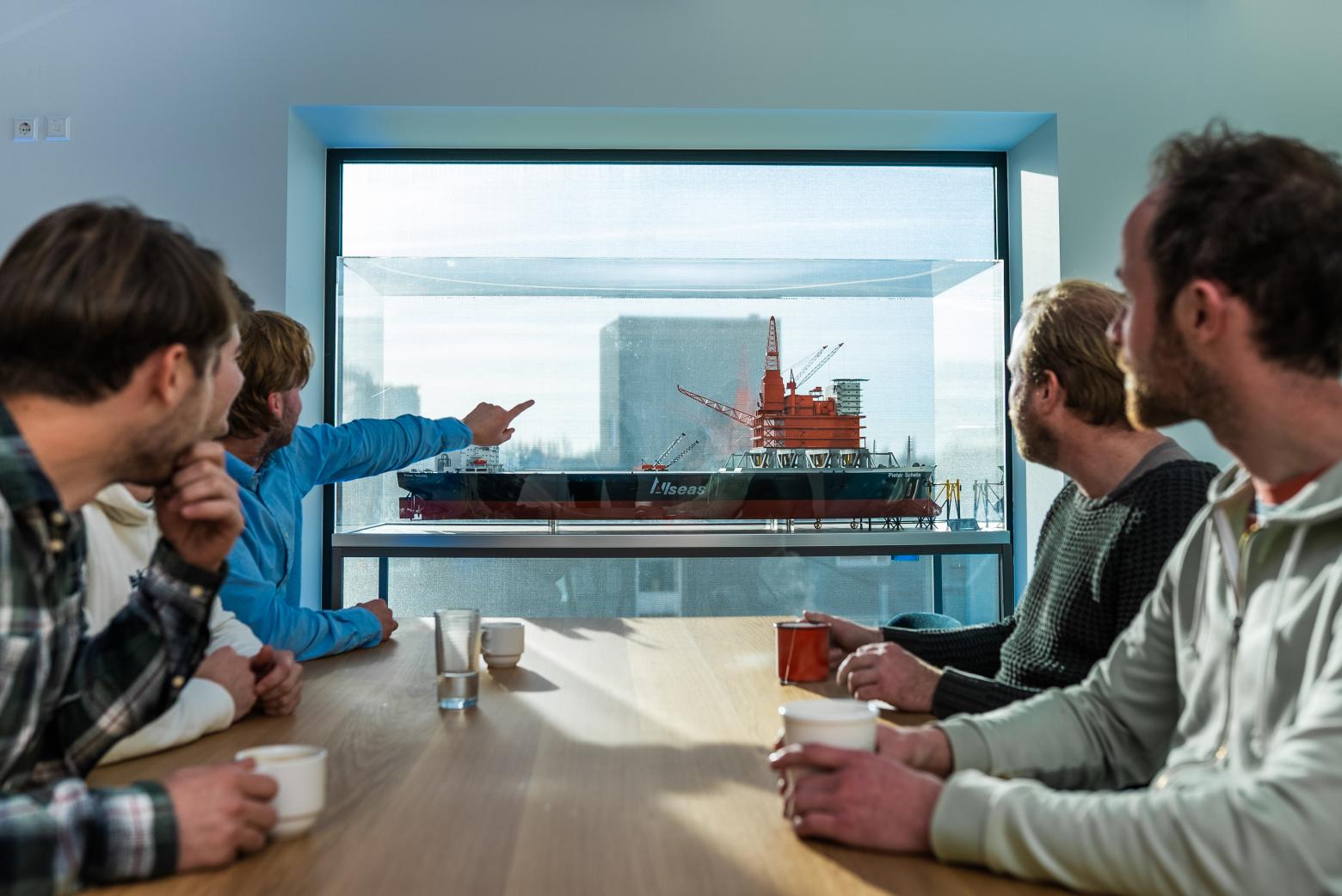 Employees looking at a vessel model
